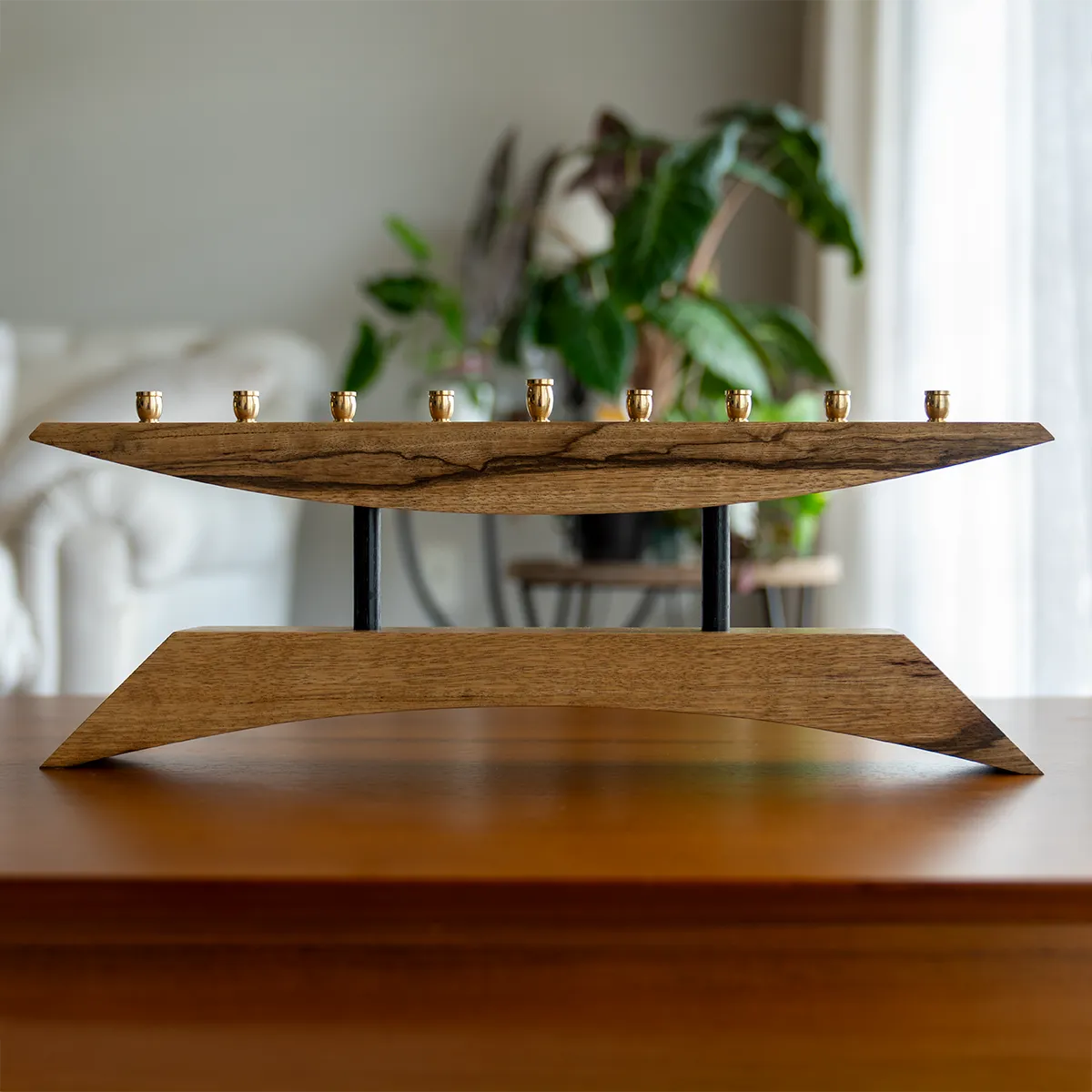 East of the Sun modern wooden menorah in black limba hardwood with brass candle cups