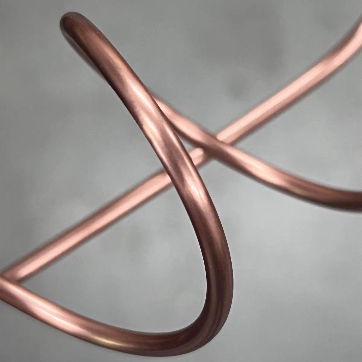 Close-up of handcrafted spiral copper support for Lean on Me propagation vase, highlighting metalwork detail.
