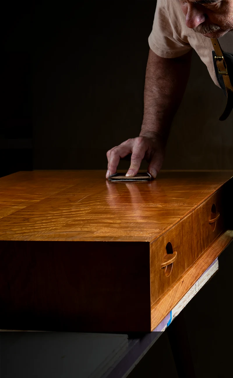 Richard hand-rubbing the finish on the Ania desk in the Dovetails & Stitches Birmingham studio.