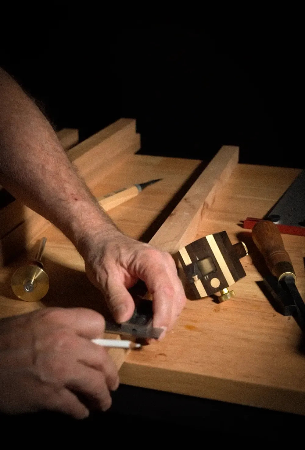 Craftsman laying out a mortise on a cherry furniture leg using traditional hand tools on a woodworking bench
