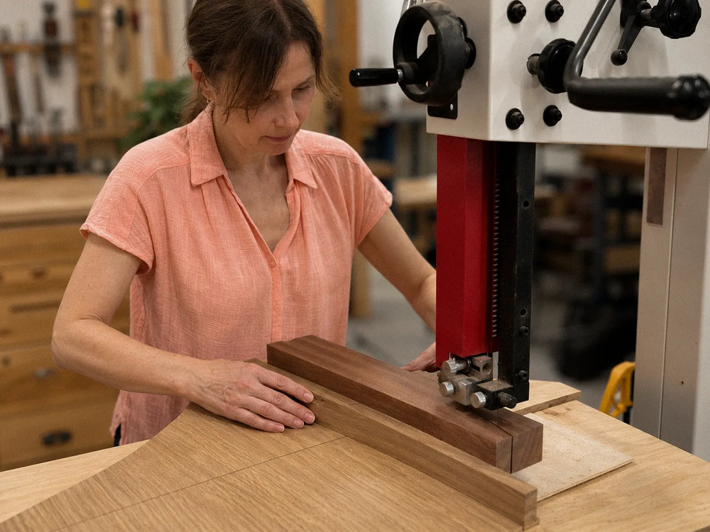 Asha shaping a wooden menorah body at the bench in the Dovetails and Stitches studio
