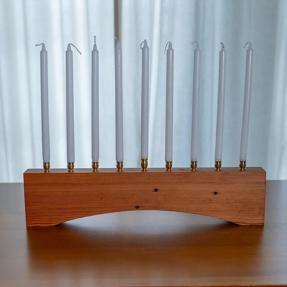 Farmhouse menorah made from reclaimed heart pine, displayed with Hanukkah candles to show traditional style and modern craftsmanship.