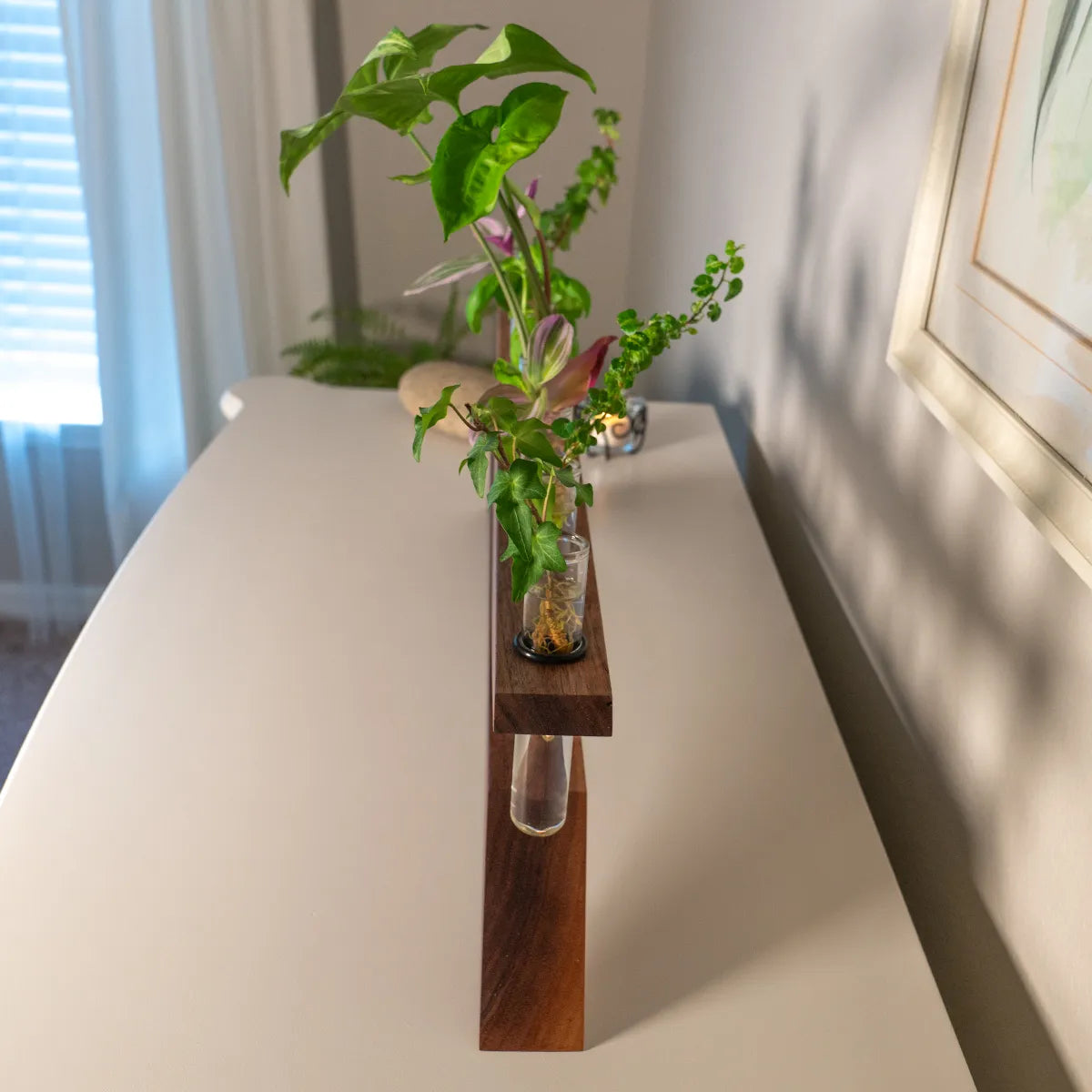 End view of handmade plant propagation vase in walnut showing polished copper standoffs and seven glass test tubes