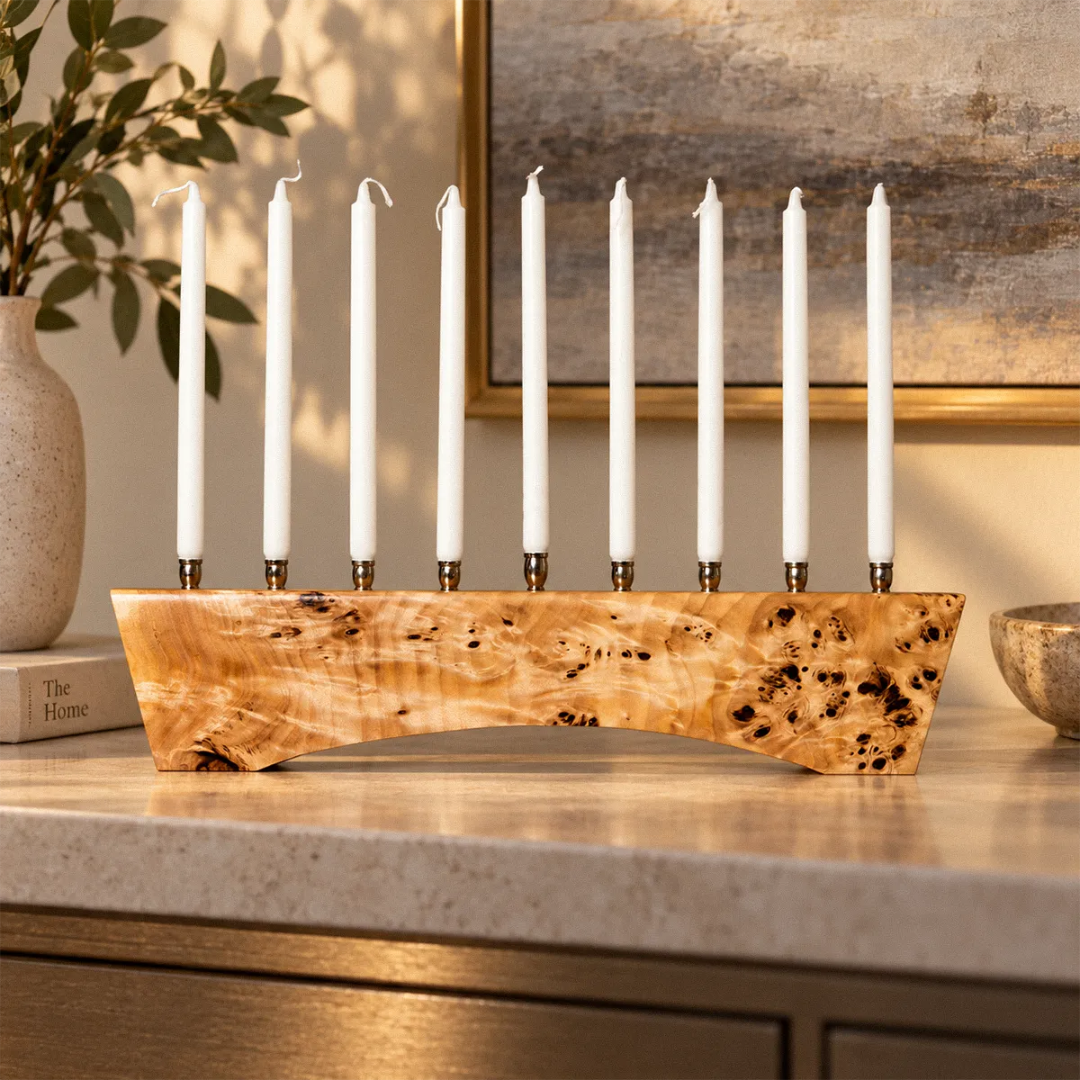 Hey Jude luxury menorah in solid Mappa burl with nine nickel candle cups, low light raking across the lacquered surface to show the chatoyant figure