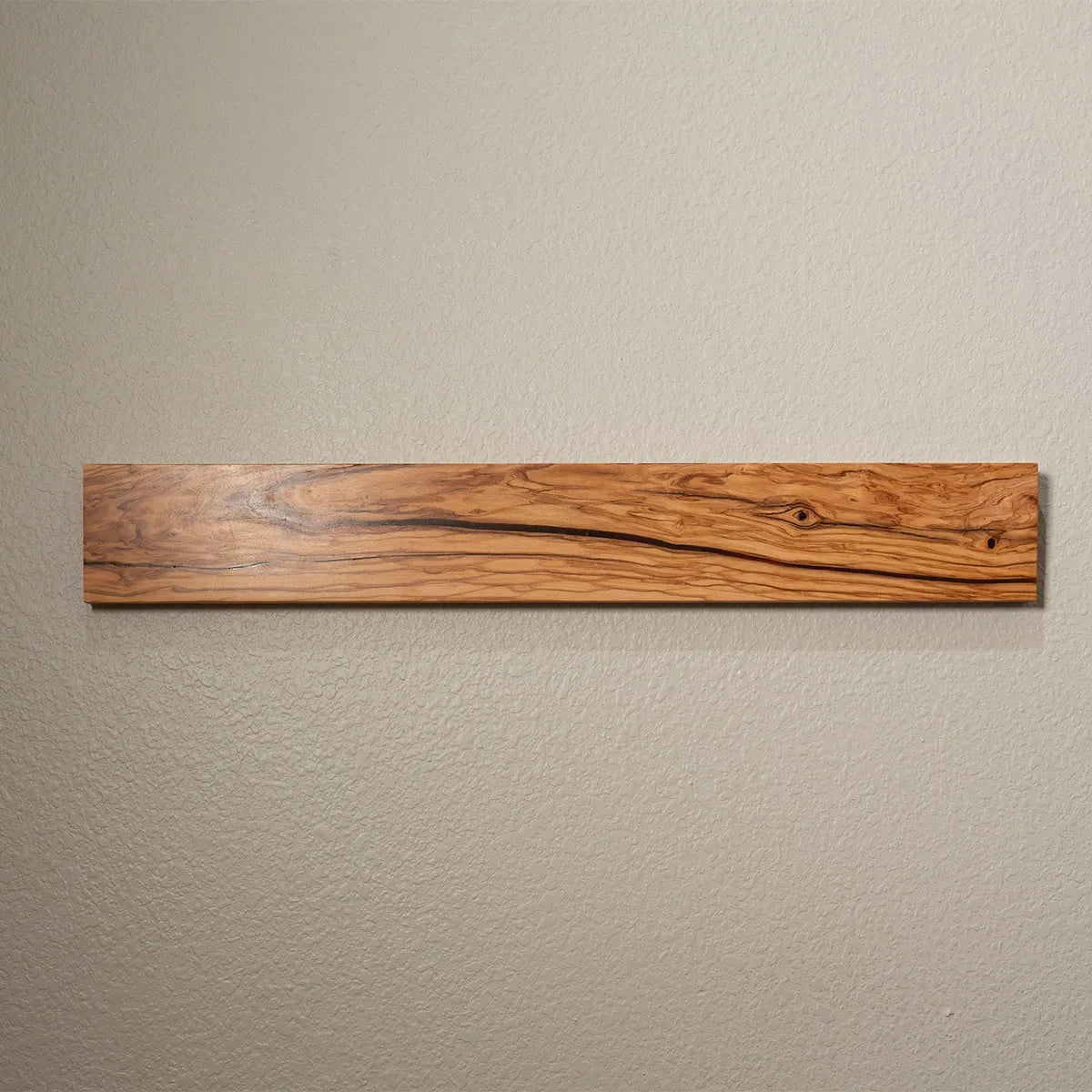Wall-mounted olive wood magnetic knife bar with no knives attached