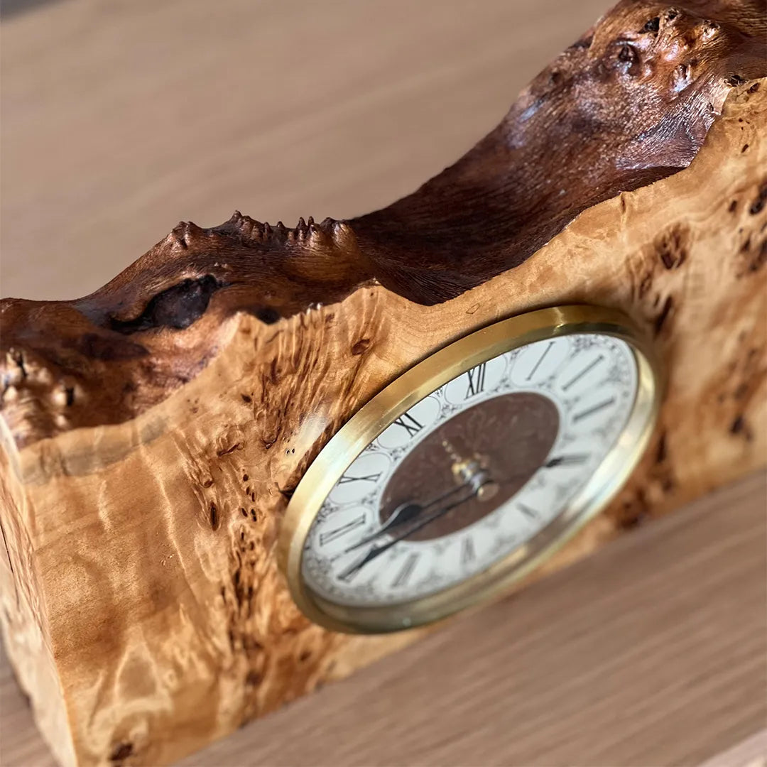 detail view of a one-of-a-kind mappa burl mantel clock with classic brass dial and sculptural wood contours
