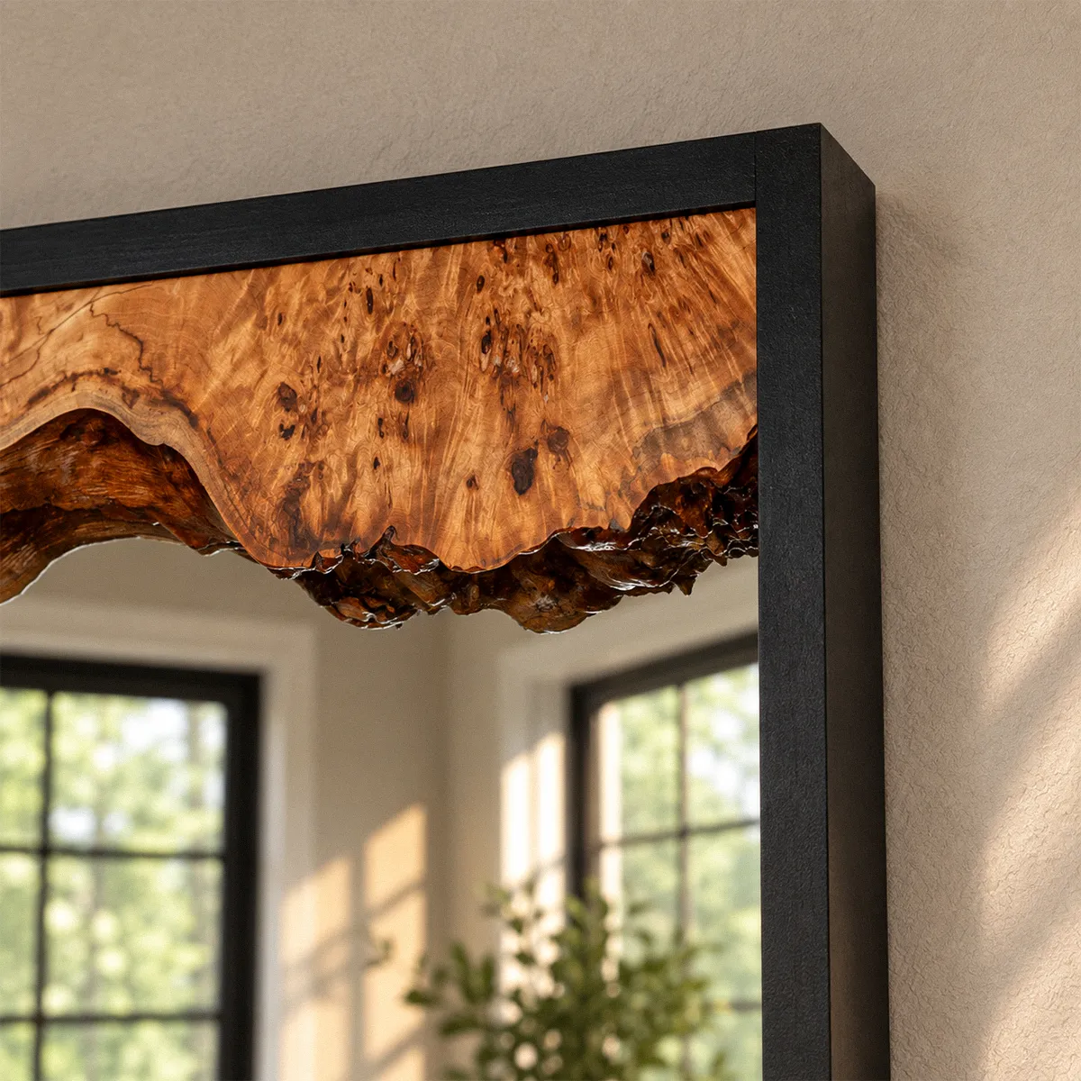 Close view of the live edge where the burl meets the mirror glass, showing the figured grain and dark eyes