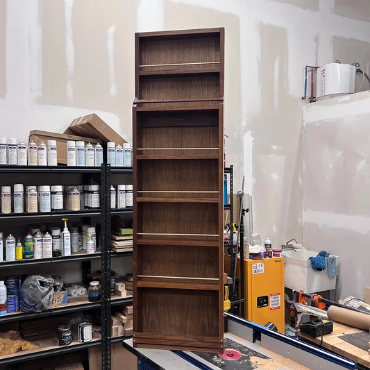 Medium A Taste of Honey walnut spice rack with stepped profile and brass gallery rails, photographed in the woodworking studio.