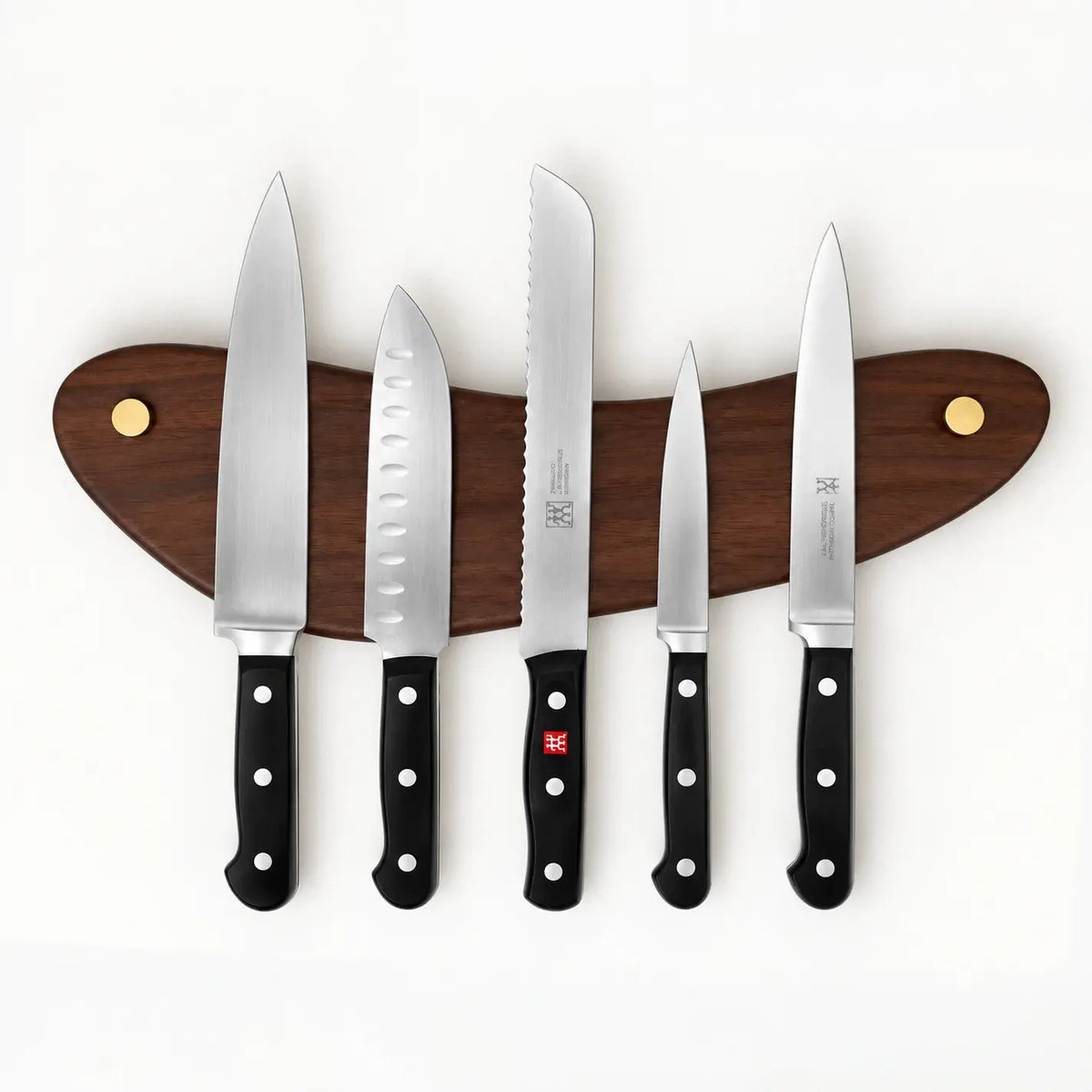 The Look of Love walnut magnetic knife rack mounted level, holding five knives on concealed magnets with brass screw caps at each end