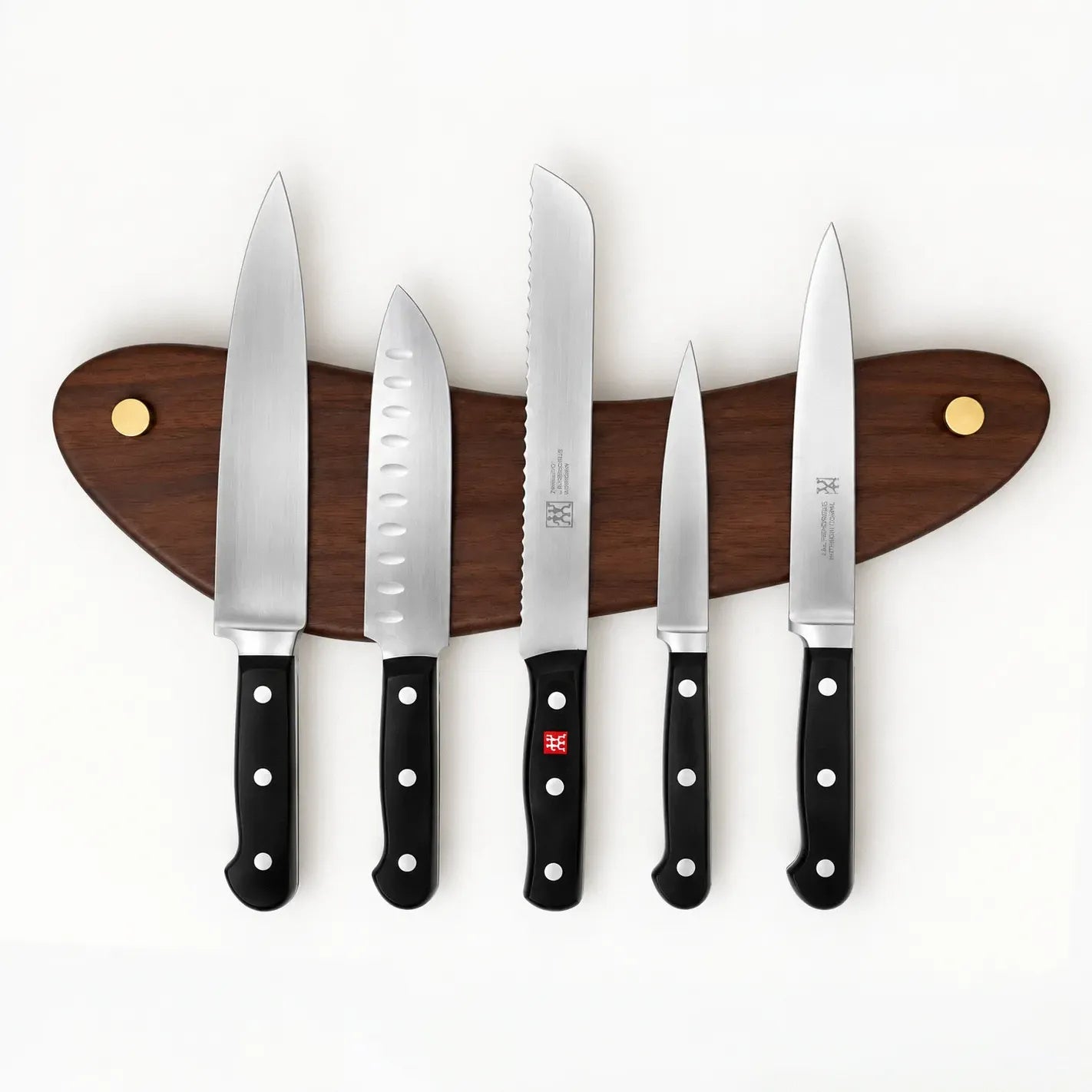 The Look of Love walnut magnetic knife rack mounted level, holding five knives on concealed magnets with brass screw caps at each end