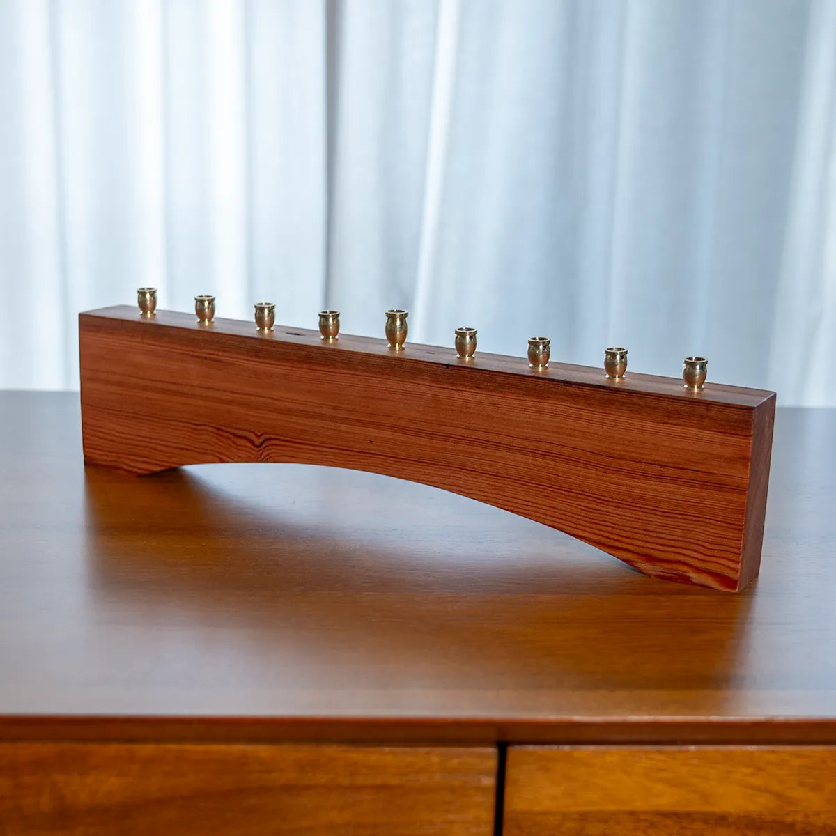 Angled side view of a farmhouse menorah in reclaimed heart pine, highlighting arched base and rustic modern style for Hanukkah decor.