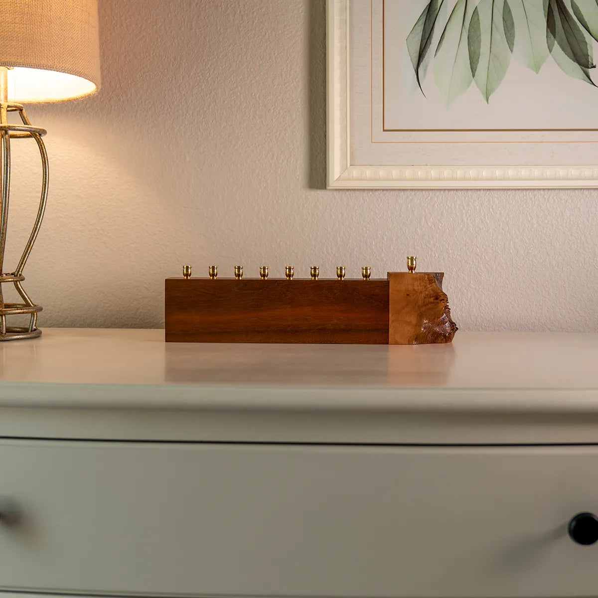 walnut and mappa burl menorah with live edge detail displayed under framed artwork