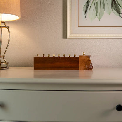 walnut and mappa burl menorah with live edge detail displayed under framed artwork