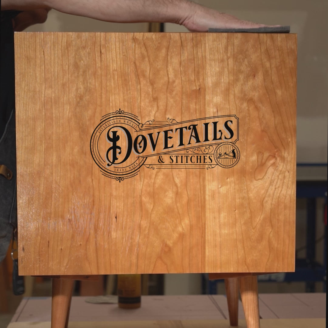 Video of Richard hand-rubbing a beeswax finish on a cherry mid-century modern desk, highlighting the handcrafted finishing process