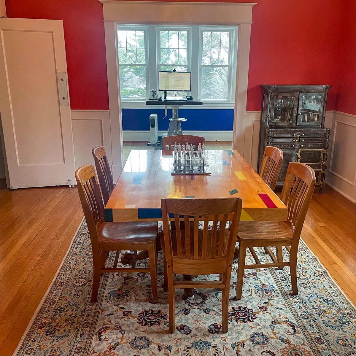 Custom reclaimed gym floor table crafted from vintage basketball court maple, shown set up as a dining table in a finished home
