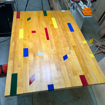 Handmade work in progress reclaimed gym floor table top in progress, featuring restored maple boards with  basketball court color markings