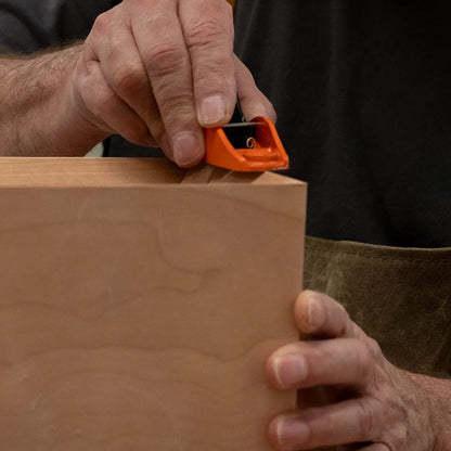 Richard hand-cutting the counter bevel on a cherry mid-century modern Ania desk, showcasing craftsmanship and detail in custom woodworking