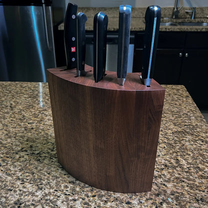 Sculptural mid-century modern knife block in solid walnut, shown from a three-quarter angle.