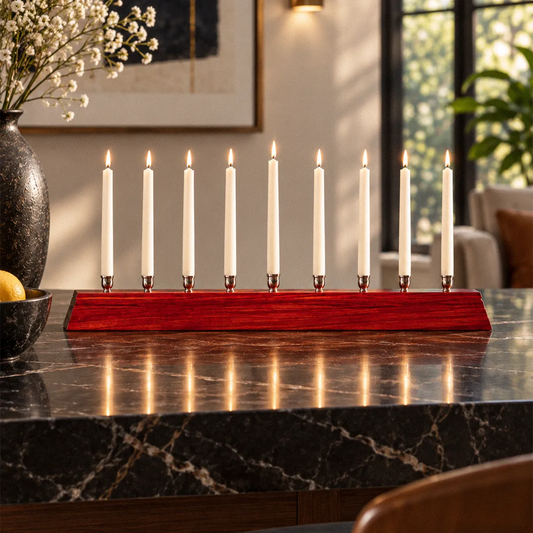 Shine a Light minimalist padauk menorah with nine nickel candle cups and lit white taper candles in a modern interior.