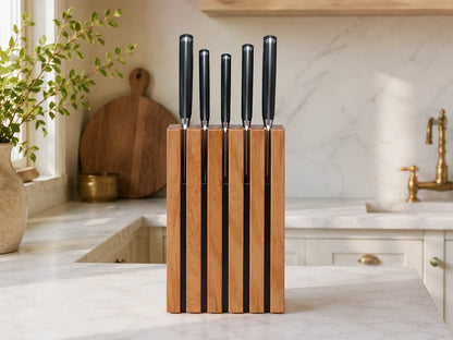 front view of The Chain knife block in solid cherry holding kitchen knives