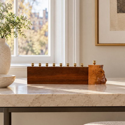 Unique walnut and Mappa burl menorah, live edge, with eight brass candle cups in a row and the shamash raised on a live-edge burl block.