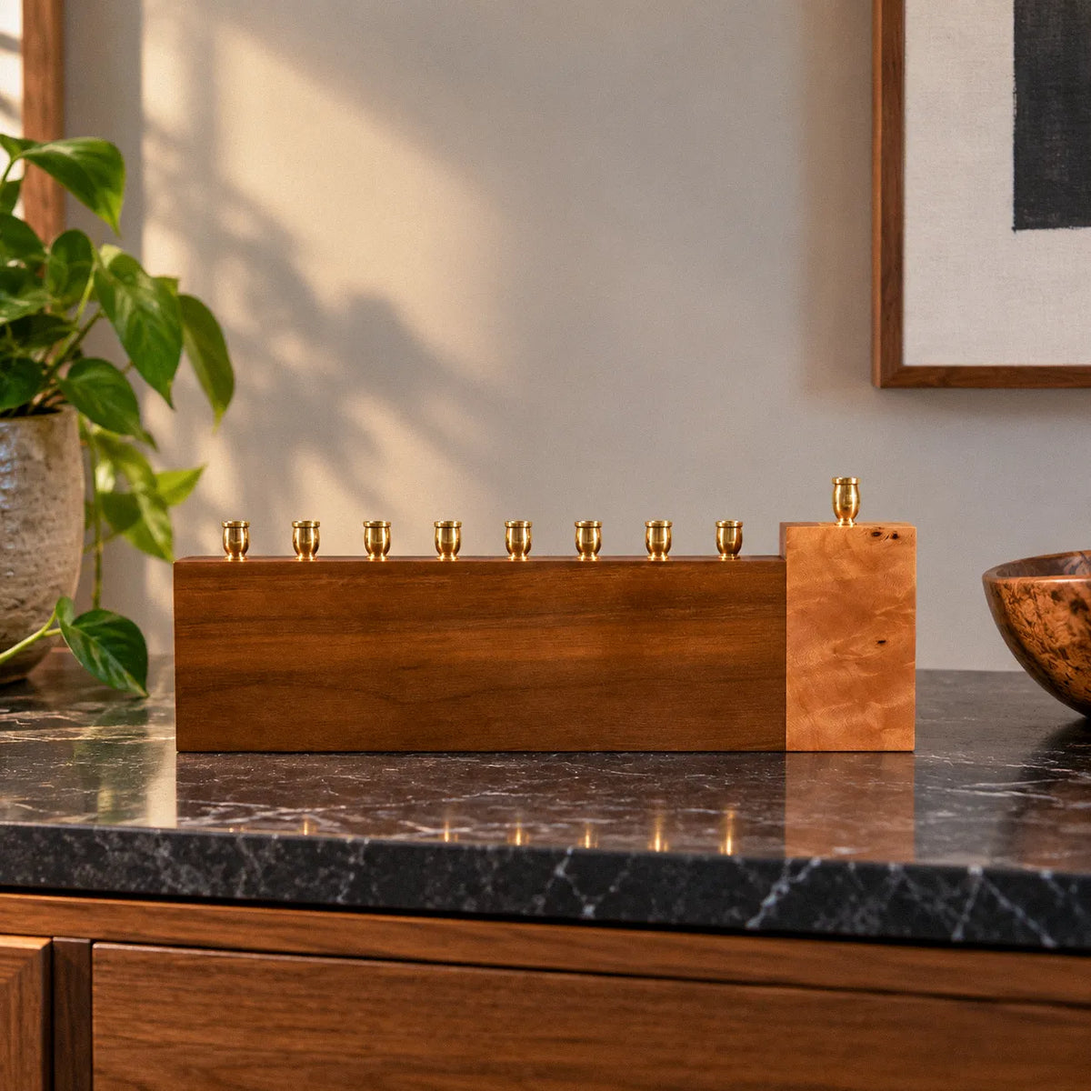 Straight-edge unique walnut and Mappa burl menorah, with eight brass candle cups along the walnut bar and the shamash raised on a squared burl block.
