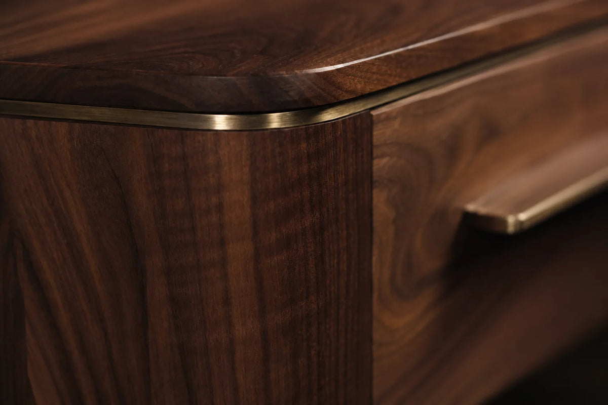 Close detail of a walnut corner with a brass edge inlay, softened by hand
