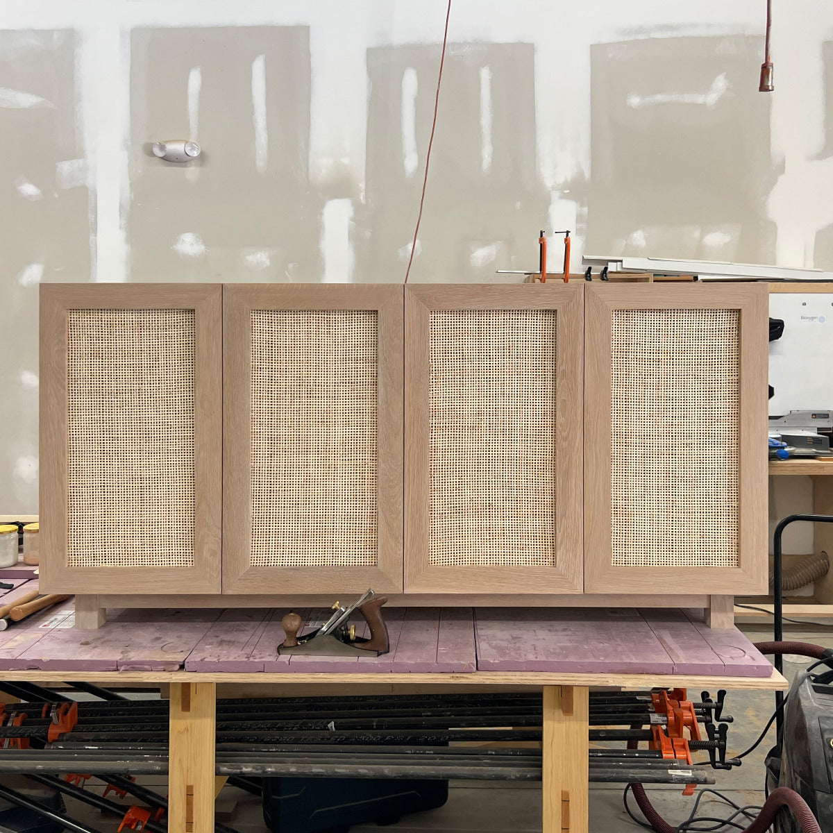 white oak media console with soft close rattan doors
