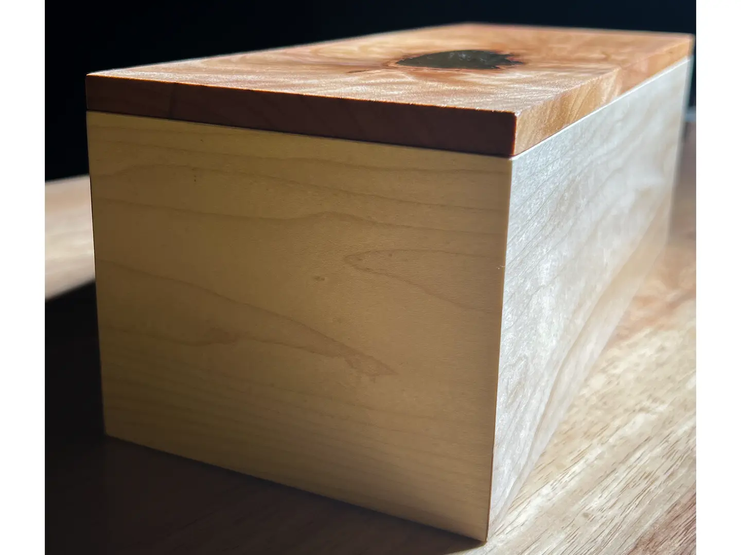 A small wooden box made from hard maple and a cherry top